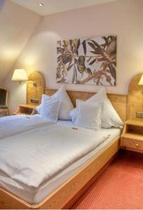 Schlafzimmer mit einem Bett mit weißer Bettwäsche und Kissen in der Unterkunft Zur alten Brücke in Schiltach