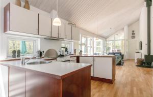 a kitchen with white cabinets and a kitchen island at Rubinsen Skovhuse in Tofte