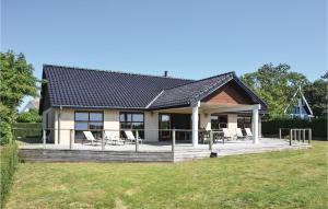 una casa con un terrazzo con sedie sopra di Four-Bedroom Holiday Home In Humble a Humble
