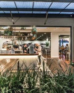 a woman standing at a counter in a restaurant at Huskisson Hotel in Huskisson