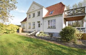 a white house with a fence and a yard at Awesome Home In Assens With Sauna, Internet And Indoor Swimming Pool in Årø