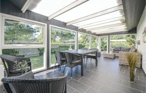 a screened in porch with a table and chairs at Nice Home In Eg With Wifi in Åstrup