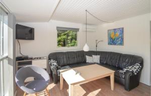 Bøtø ByにあるAmazing Home In Vggerlse With 3 Bedrooms And Saunaのリビングルーム(黒い革張りのソファ、テーブル付)