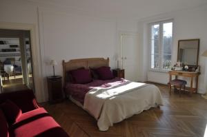 1 dormitorio con cama, ventana y sofá en Château de Bel Ebat, en Nozay
