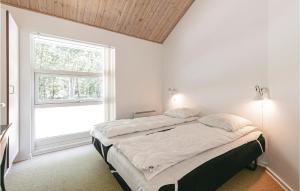 1 dormitorio con 1 cama y ventana grande en Rubinsen Skovhuse, en Hasle