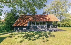 a small house with a roof on a grass field at 3 Bedroom Cozy Home In Gudhjem in Gudhjem