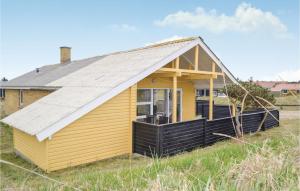 BjerregårdにあるNice Home In Hvide Sande With Kitchenの金属屋根の小さな黄色い家