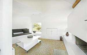 a white living room with a couch and a table at Stunning Home In Svaneke With House Sea View in Svaneke