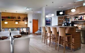 eine Bar in einem Restaurant mit weißen Stühlen in der Unterkunft Hotel Agneshof Nürnberg in Nürnberg