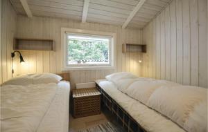 two beds in a room with a window at Holiday Home Øreflak Ebeltoft Vi in Ebeltoft