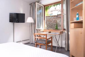 a hotel room with a desk and a window at Hotel Agneshof Nürnberg in Nuremberg