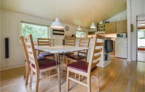 a dining room and kitchen with a table and chairs at Holiday Home Øreflak Ebeltoft Vi in Ebeltoft
