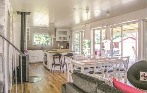 a kitchen and living room with a table and chairs at Amazing Home In Bolmsö in Bolmsö +12 photos
