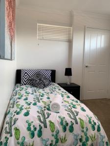 a bedroom with a bed with a comforter on it at Carpe Diem South #3 in Busselton