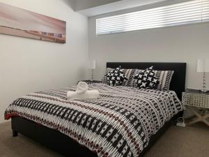 1 dormitorio con 1 cama en blanco y negro y ventana en Carpe Diem South #3, en Busselton