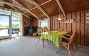 a dining room with a green table and chairs at Holiday Home Lakolk Iv Denmark in Bolilmark