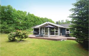 a small house with a large deck in a yard at Holiday Home Krondyrstien Væggerløse Denm in Marielyst +10 photos