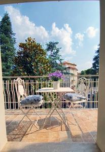 a table and chairs with a vase of flowers on a balcony at Residenza Chiara in Forlì