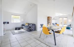 a living room with a table and yellow chairs at Two-Bedroom Holiday Home In Farevejle in Fårevejle