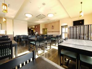 une salle à manger avec des tables et des chaises dans l'établissement Hotel Route-Inn Takasaki Eki Nishiguchi, à Takasaki