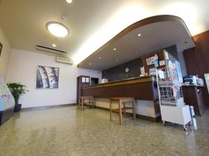 una sala de espera con un mostrador y una mesa en Hotel Route-Inn Takasaki Eki Nishiguchi, en Takasaki