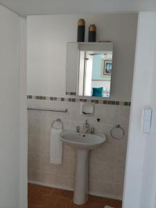 a bathroom with a sink and a mirror at Rooftops in Bredasdorp
