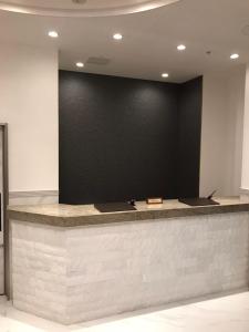 a lobby with a counter with a black wall at Akasaka Urban Hotel Annex in Tokyo