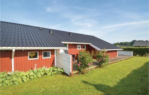 una casa roja con una valla y un patio en Amazing Home In Sjlund With Wifi en Sønder Bjert