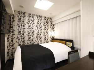 a bedroom with a bed with a black and white wallpaper at APA Hotel Iidabashi-Eki Minami in Tokyo