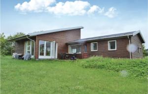 une petite maison avec une cour herbeuse devant elle dans l'établissement Amazing Home In lsted With Kitchen, à Ølsted