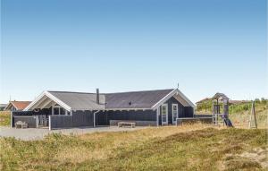 a black building with a playground in front of it at Three-Bedroom Holiday Home In Hvide Sande in Bjerregård