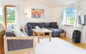 - un salon avec un canapé bleu et une table dans l'établissement Amazing Home In lsted With Kitchen, à Ølsted
