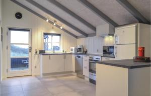 a large kitchen with white appliances and a window at Three-Bedroom Holiday Home In Hvide Sande in Bjerregård