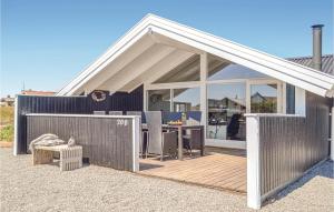 a pavilion with a table on a wooden deck at Three-Bedroom Holiday Home In Hvide Sande in Bjerregård