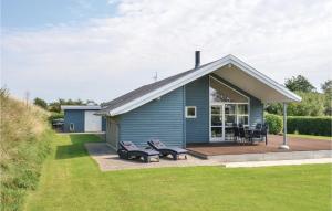 a blue house with a deck and chairs at Awesome Home In Knebel With 3 Bedrooms, Sauna And Wifi in Knebel