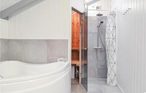 a bathroom with a white tub and a shower at Three-Bedroom Holiday Home In Hvide Sande in Bjerregård