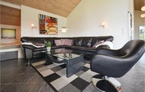 KnebelにあるAmazing Home In Knebel With Saunaのリビングルーム(黒い革張りのソファ、テーブル付)