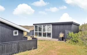 una casa negra con una gran puerta de cristal en Holiday Home Tingodden Hvide Sande Vi, en Hvide Sande