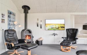 a living room with two chairs and a fireplace at 4 Bedroom Stunning Home In Hvide Sande in Hvide Sande