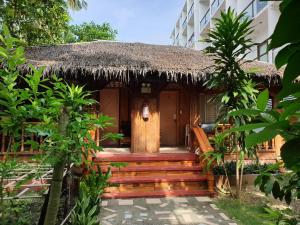 un edificio resort con techo de paja y escalera en Roy's Rendezvous Boracay, en Boracay