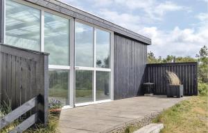 una casa con grandes ventanales y patio en Holiday Home Tingodden Hvide Sande Vi, en Hvide Sande
