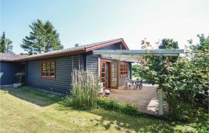 uma pequena casa azul com um deque de madeira em Stunning Home In Torrig L With House Sea View em Torrig