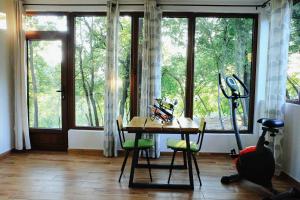 a room with a table and chairs and windows at Donkey Farm Martinici - Farma magaraca Martinici in Danilovgrad