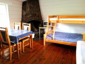 a room with a table and bunk beds and a fireplace at Driva Hytter in Oppdal