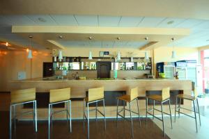 a kitchen with a bar with chairs around it at Menada Apartments in Sunny Beach in Sunny Beach
