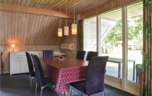 une salle à manger avec une table et des chaises rouges dans l'établissement Stunning Home In Oksbl With Private Swimming Pool, Can Be Inside Or Outside, à Oksbøl