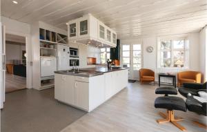 ØstermarieにあるBuskegaardの白いキャビネットとキッチンアイランド付きのキッチン