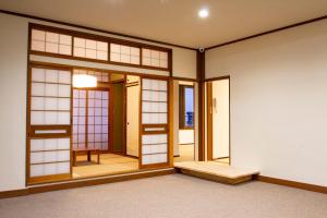 an empty room with a door and windows at Japanese House Osaka Sennan Hotel（大阪泉南酒店和築） in Tannowa