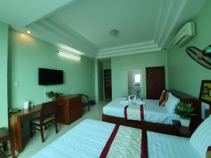 um quarto de hotel com duas camas e uma televisão em Khách sạn Trường Sơn em Ho Chi Minh