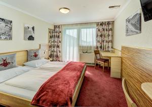 pokój hotelowy z łóżkiem i biurkiem w obiekcie Mountainlovers Berghotel SeidlAlm w Saalbach Hinterglemm
